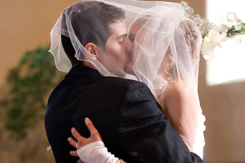 Brautpaar das sich küsst, der Bräutigam unter dem Schleider der Braut - Bild von Hochzeitsfotograf UNIKATUM
